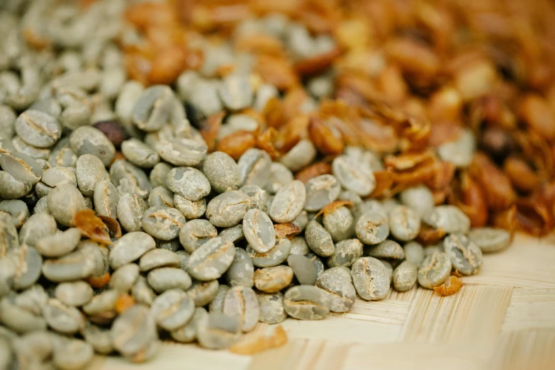 a pile of coffee beans sitting on top of a wooden table, by Emma Andijewska, a green, golden raito, close up image, 王琛