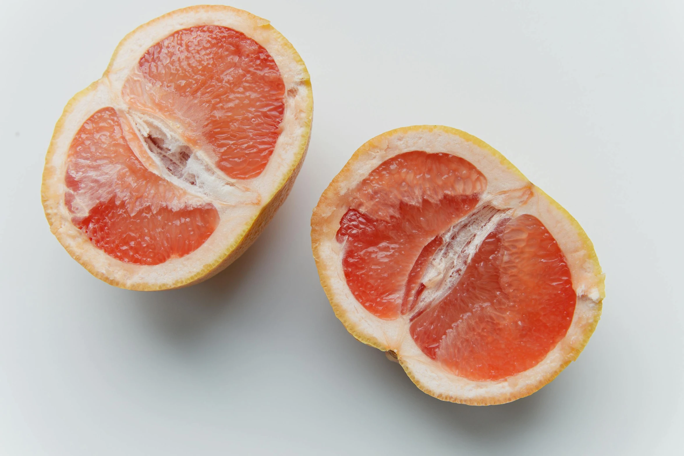 two halves of a grapefruit on a white surface, by Julian Allen, trending on unsplash, fan favorite, epicurious, ultradetailed, aoi ogata