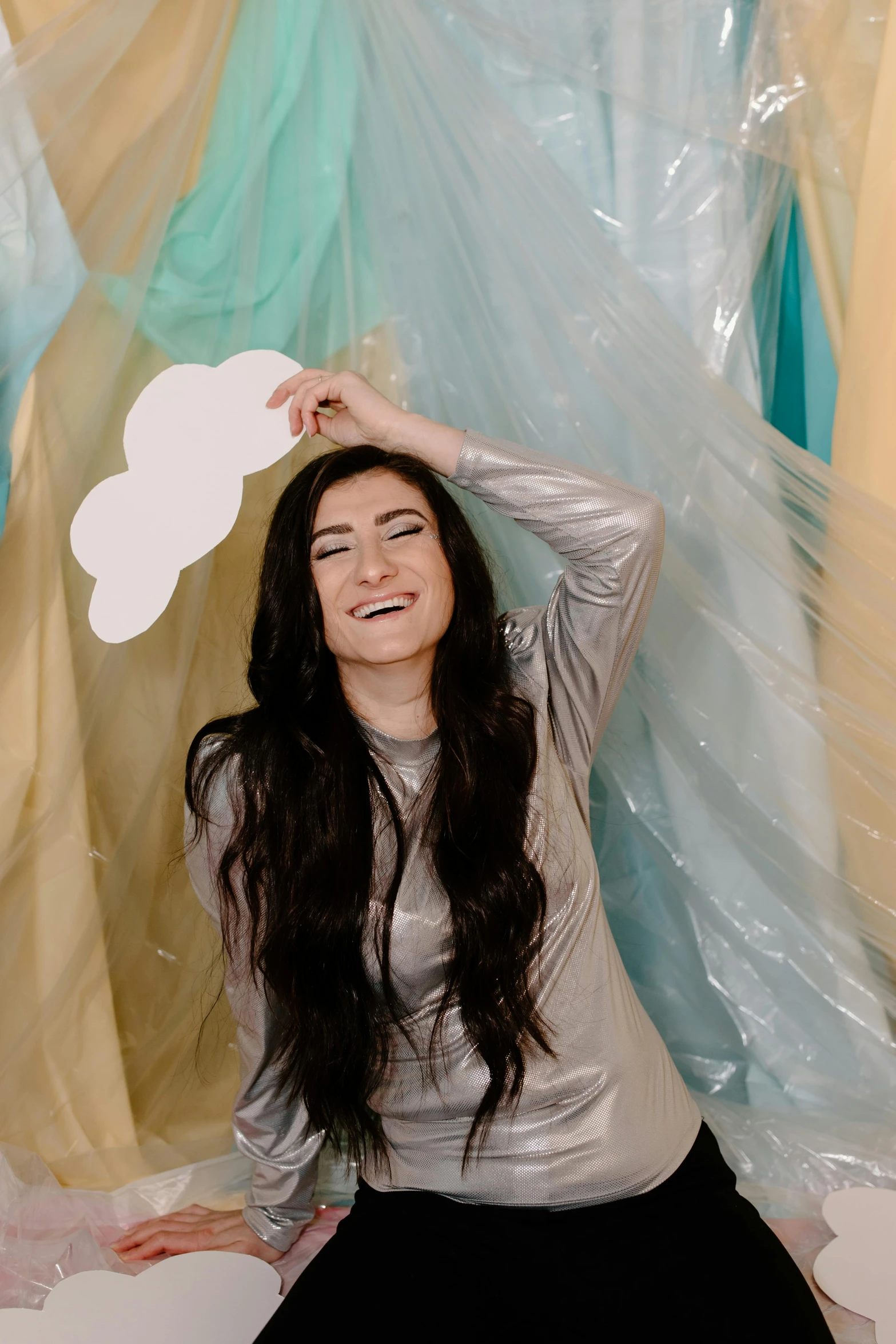 a woman holding a paper cloud above her head, an album cover, trending on pexels, diaphanous iridescent silks, smiling young woman, female with long black hair, photo booth