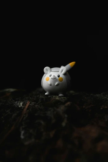a white cat figurine sitting on top of a wooden table, inspired by Yerkaland, trending on polycount, digital art, pikachu in a forest, on a dark rock background, promo image, tamagotchi