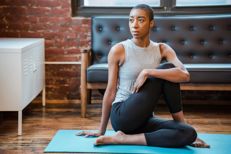 a woman sitting on a yoga mat in a living room, pexels contest winner, renaissance, african american young woman, low quality photo, thumbnail, high-resolution