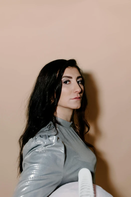 a woman sitting on top of a bed holding a remote control, an album cover, by Winona Nelson, on clear background, with long dark hair, alessio albi, headshot profile picture