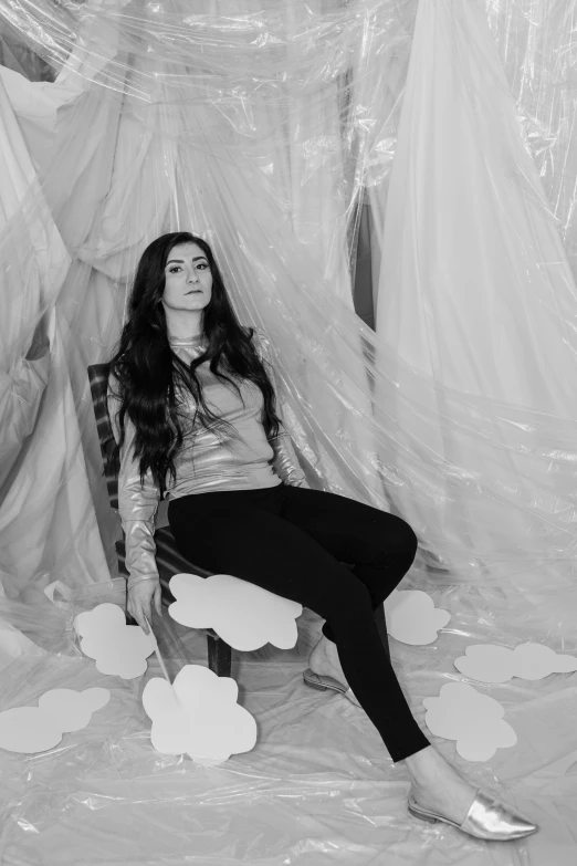 a black and white photo of a woman sitting in a chair, a black and white photo, maya ali as a wind mage, sitting in a fluffy cloud, in the gallery, ((messy))