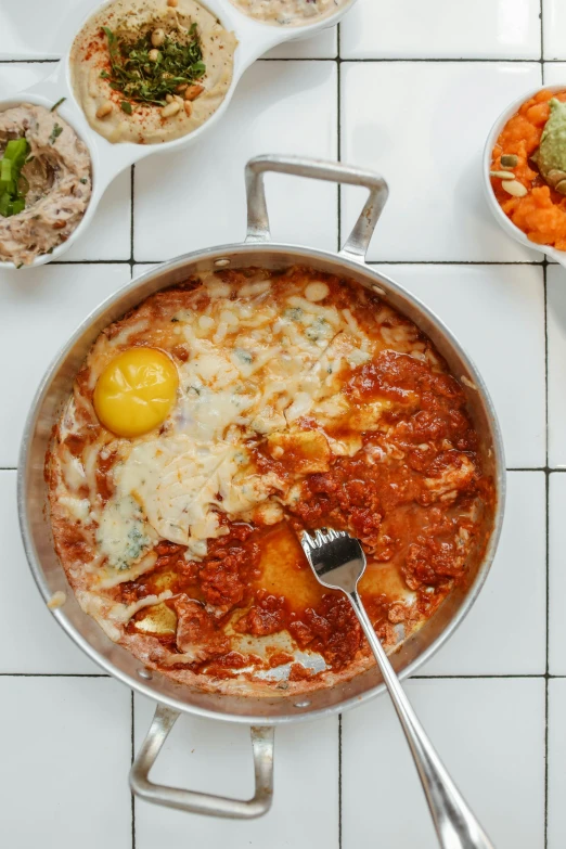 a pan filled with food sitting on top of a table, inspired by jeonseok lee, melted cheese, somalia, eggs, thumbnail