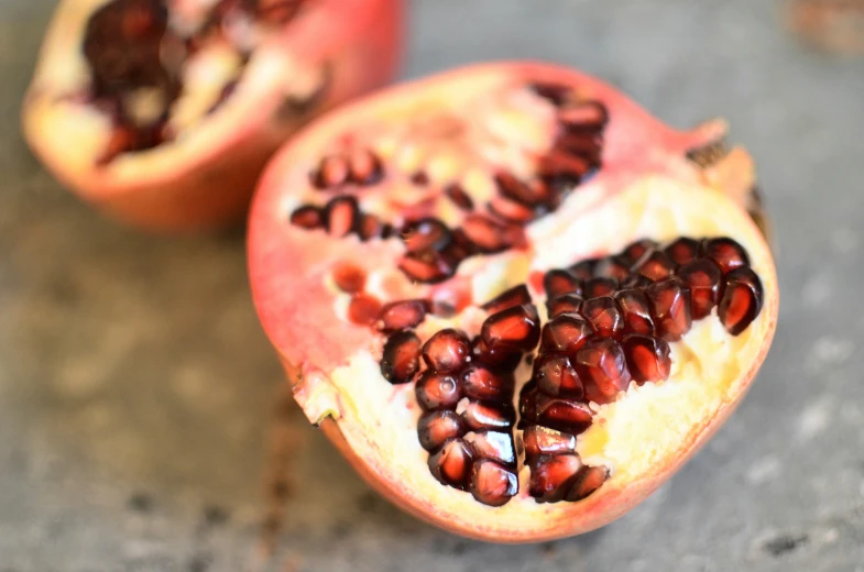 a pomegranate cut in half on a table, by Carey Morris, pexels, 🦩🪐🐞👩🏻🦳, recipe, middle close up, easy