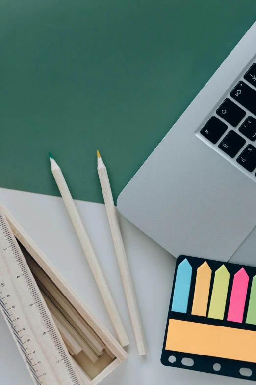 a laptop computer sitting on top of a desk, trending on unsplash, academic art, 9 9 designs, pencils, square, green colored theme