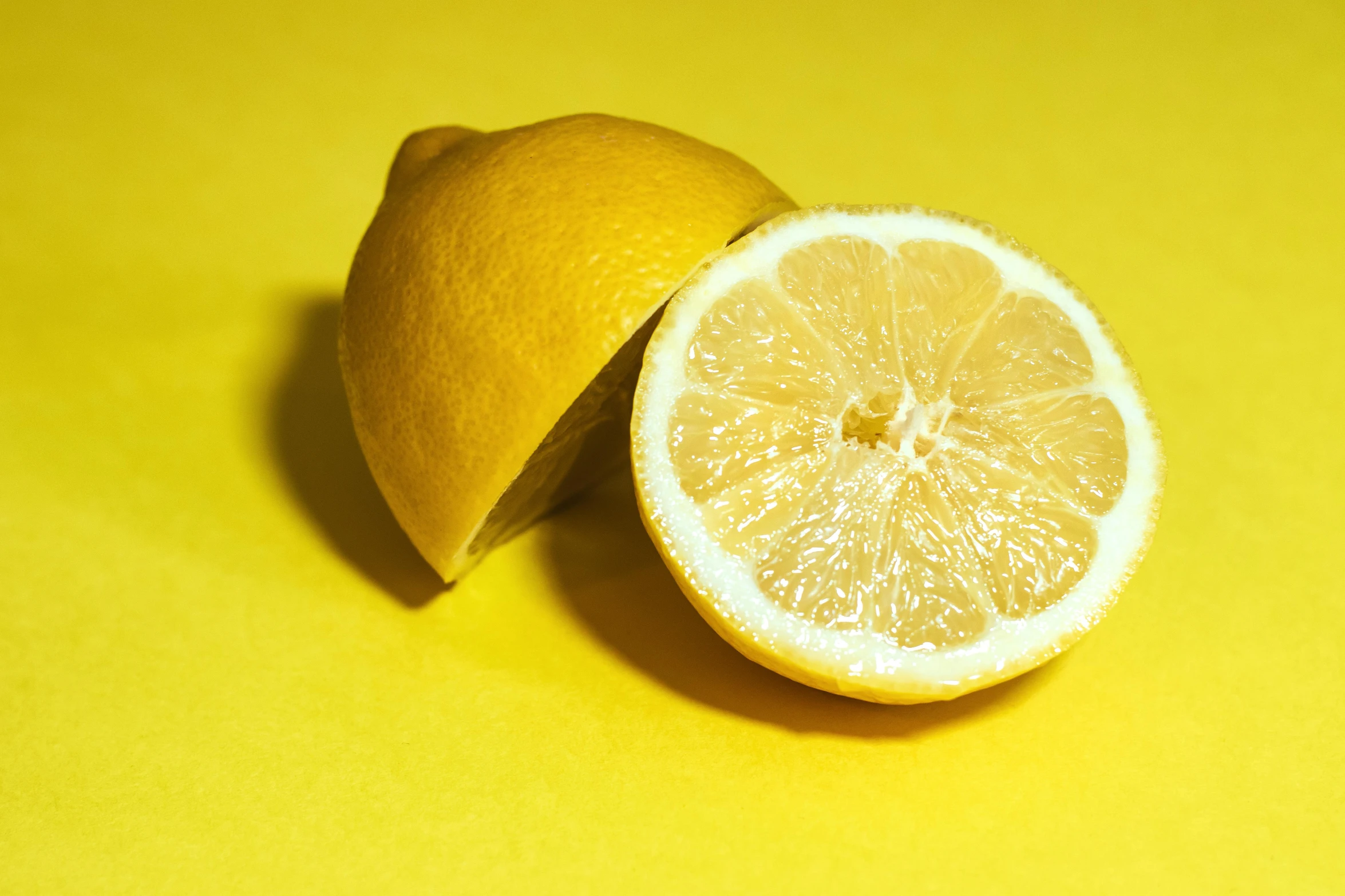 a lemon cut in half on a yellow surface, pexels, 2000s photo, mint, organic, acids