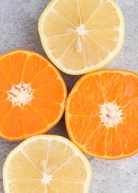 a group of oranges cut in half on a table, a portrait, by Carey Morris, trending on unsplash, on a gray background, a colorful, with lemon skin texture, vanilla