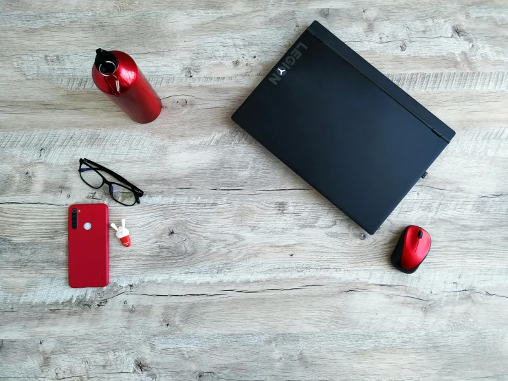 a laptop computer sitting on top of a wooden table, by Bernardino Mei, pexels contest winner, minimalism, red - black, various items, low quality photo, full body image