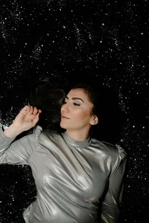 a woman standing in the rain with her hair blowing in the wind, an album cover, by Julia Pishtar, man in silver space suit, laying on her back on a bed, glittery short black hair, photo taken in 2 0 2 0