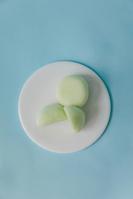 a white plate topped with slices of melon, inspired by Eva Gonzalès, unsplash, conceptual art, glowing mint face, dumplings on a plate, close-up product photo, petite pear slim figure