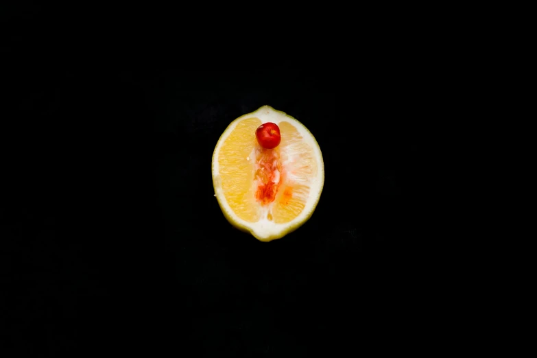 an orange cut in half on a black surface, by Jan Rustem, unsplash, red nose, contracept, lemon, a blond