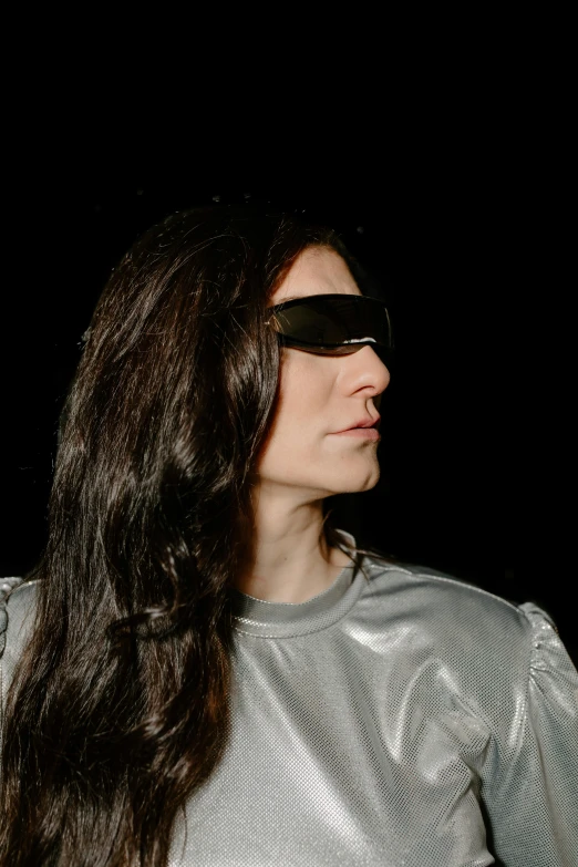 a woman wearing a silver shirt and sunglasses, inspired by Marina Abramović, with his long black hair, glowing oled visor, profile image, musician