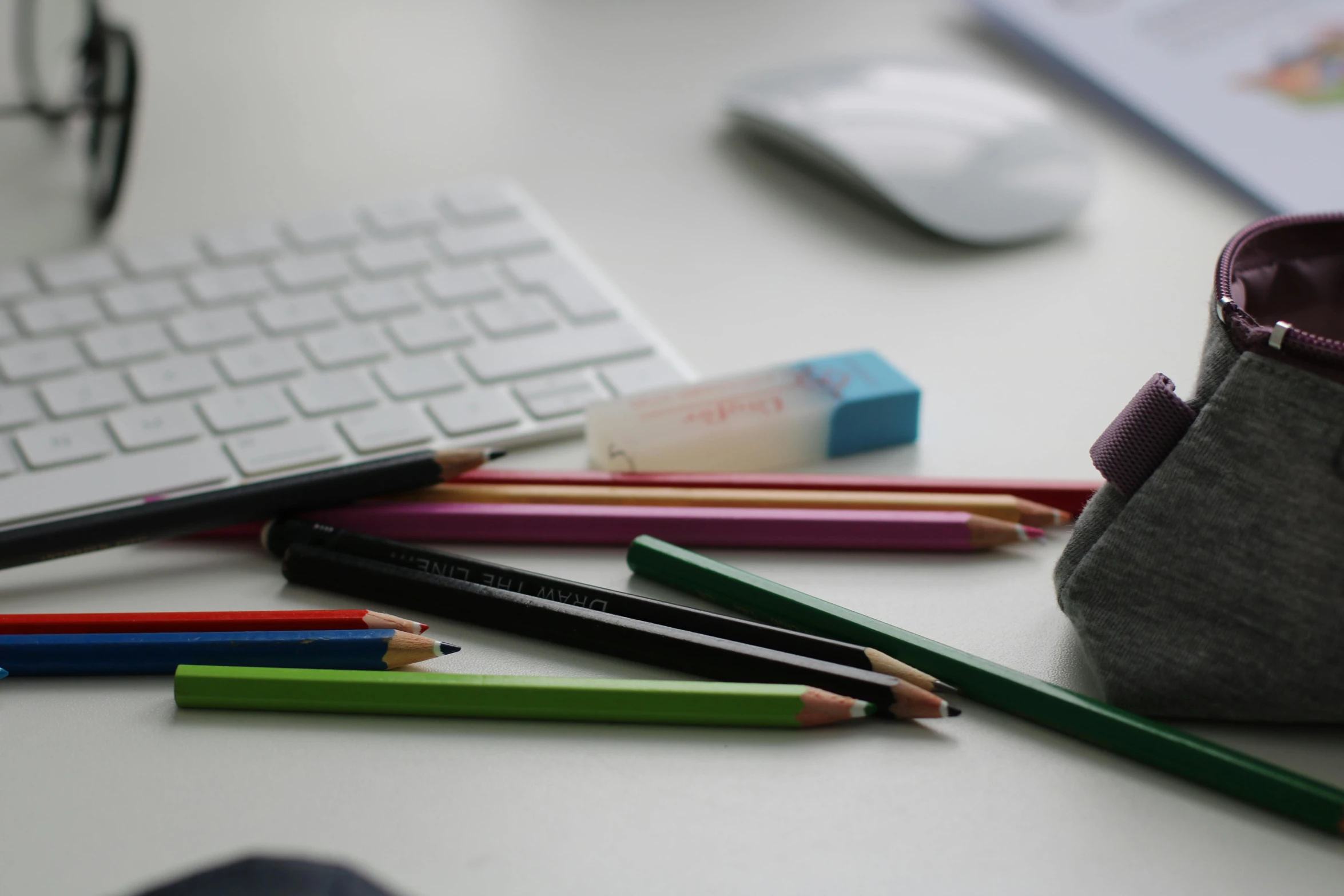 a cup filled with colored pencils next to a keyboard, a picture, by Robbie Trevino, various items, item, people at work, close - up photo