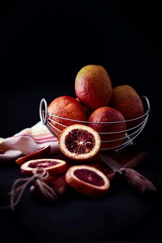 a bowl of blood oranges on a table, a still life, shutterstock contest winner, cinnamon skin color, on black background, fruit basket, with intricate detail