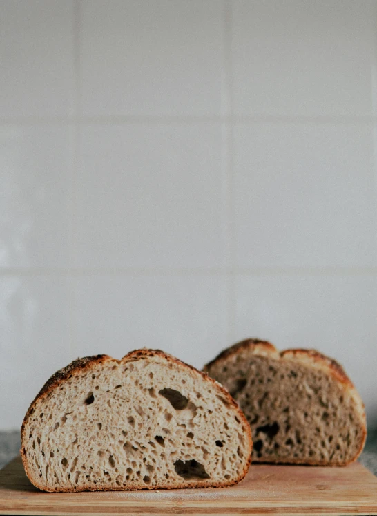 a loaf of bread sitting on top of a cutting board, a portrait, unsplash, low quality photo, backlighted, adult pair of twins, detailed product image