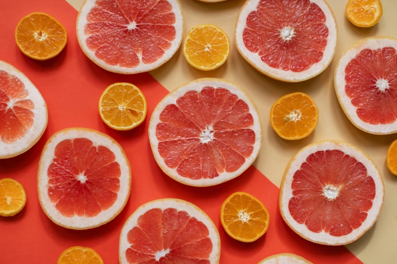 sliced grapefruits and oranges on a red and yellow background, trending on pexels, 🦩🪐🐞👩🏻🦳, background image