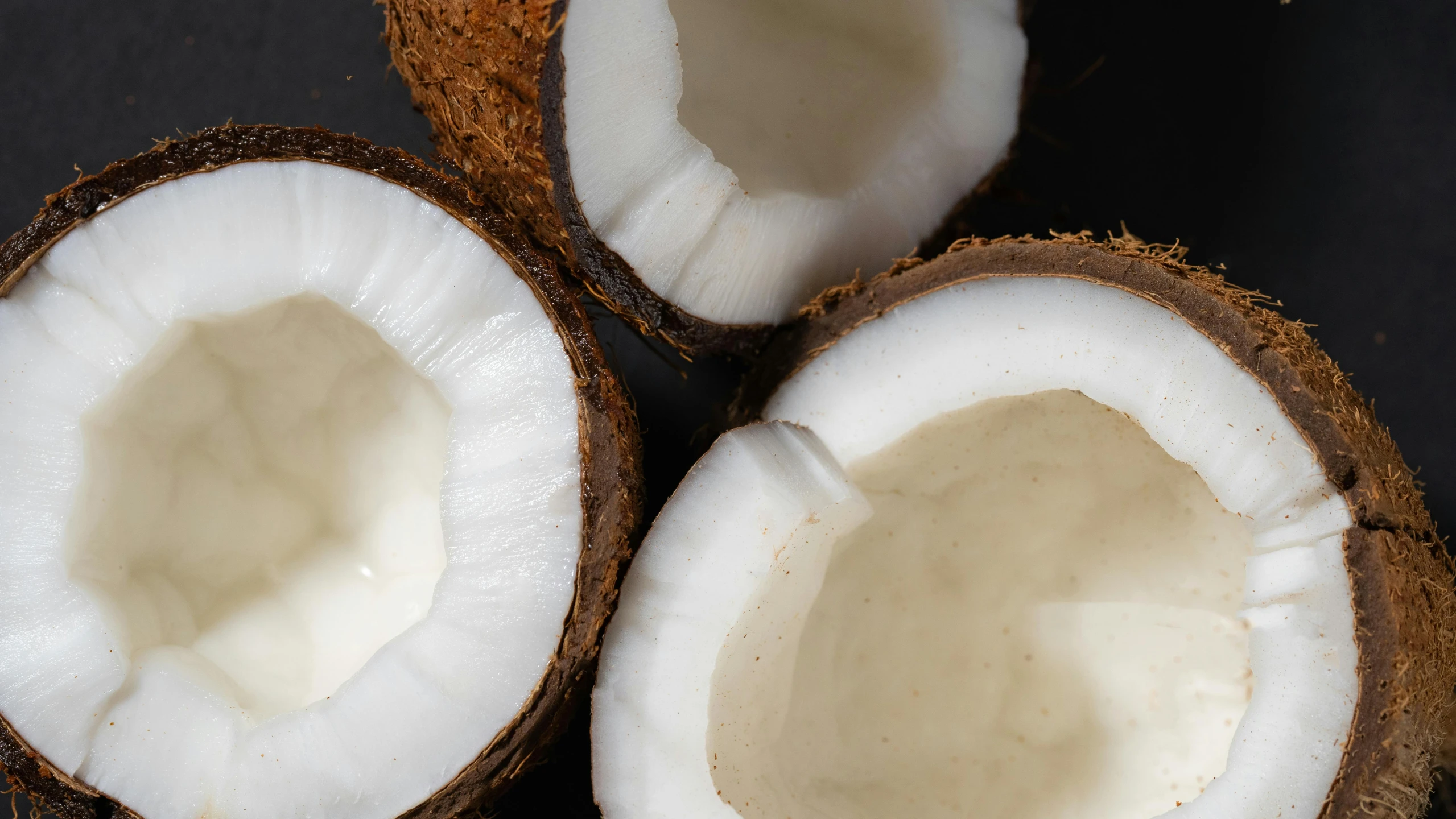 a couple of coconuts sitting on top of a table, in front of a black background, background image, multiple stories, detailed product image