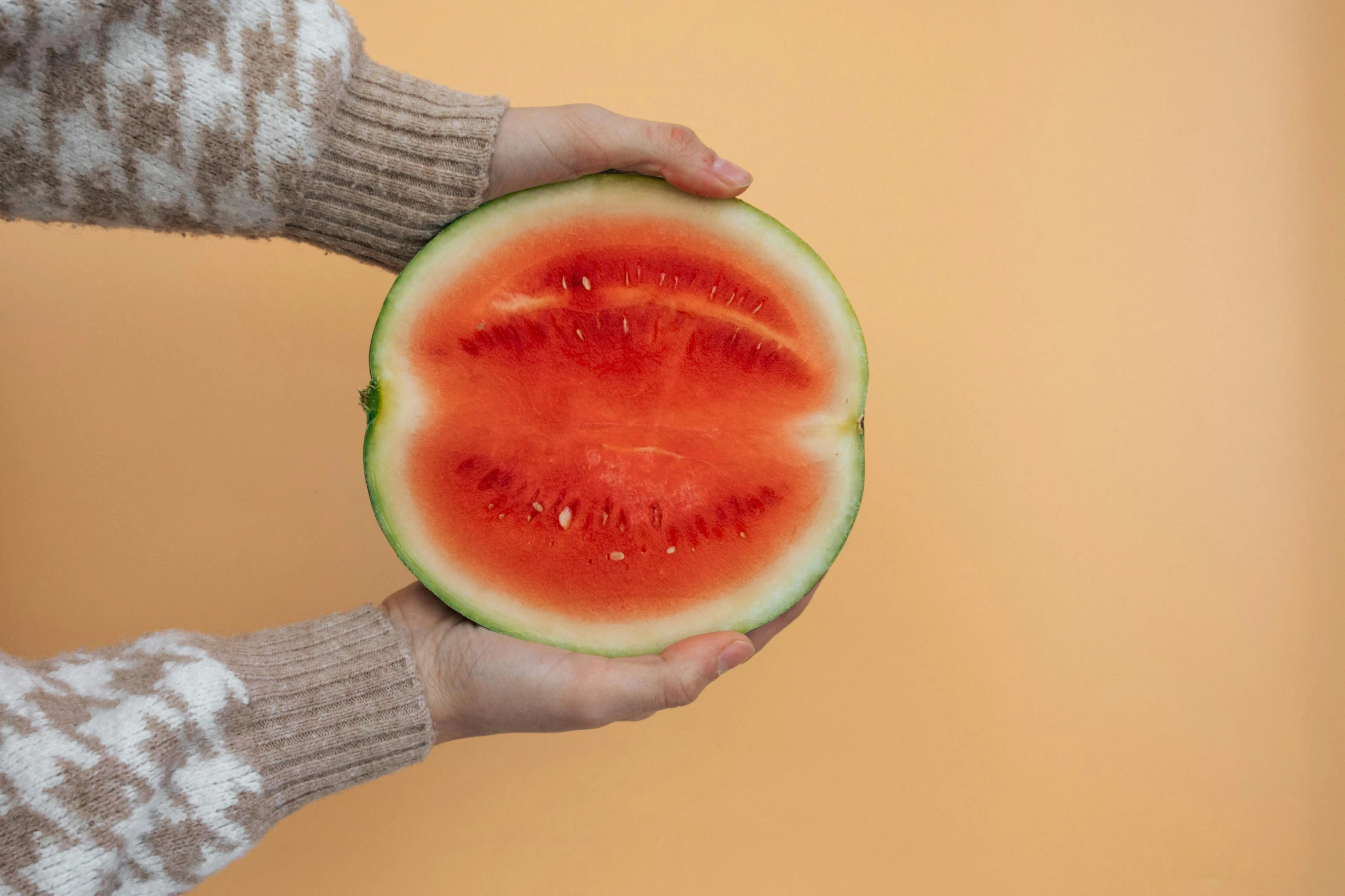 a person holding a slice of watermelon in their hands, by Julia Pishtar, hurufiyya, warm coloured, soft round features, close-up product photo, slightly turned to the right