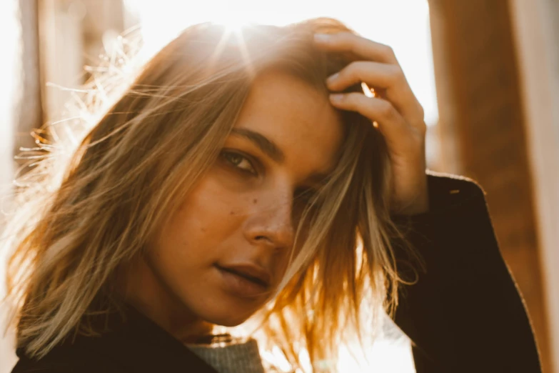 a beautiful young woman standing in front of a building, inspired by Elsa Bleda, trending on pexels, sun glare, brown-blond-hair pretty face, sydney sweeney, close up portrait of woman