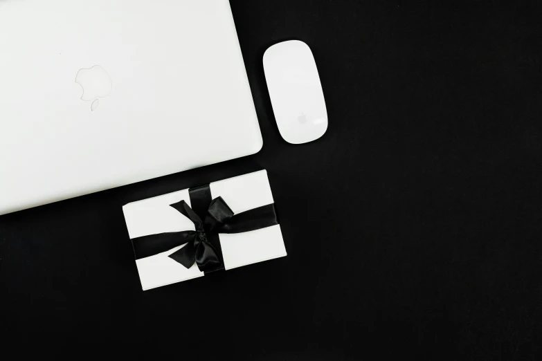 a white laptop computer sitting on top of a black table, gifts, white ribbon, all black matte product, thumbnail