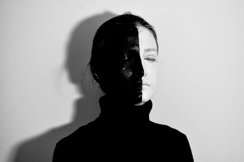 a black and white photo of a woman's face, a black and white photo, by Emily Shanks, antipodeans, image split in half, covered face, shadow effect, infp young woman