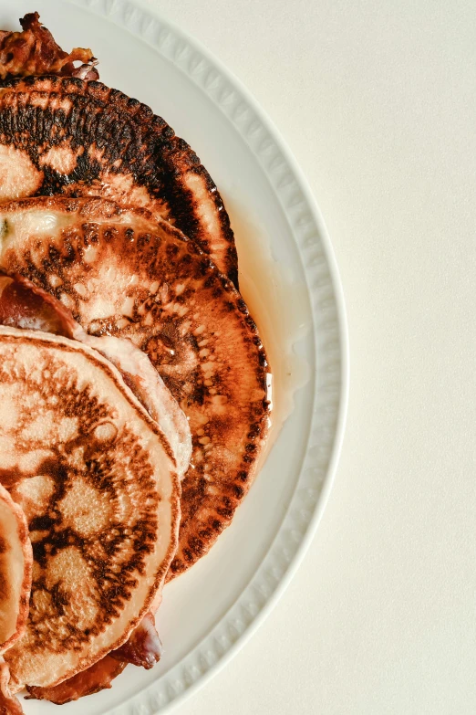 a white plate topped with pancakes covered in syrup, by Carey Morris, cinnamon skin color, sunfaded, burn