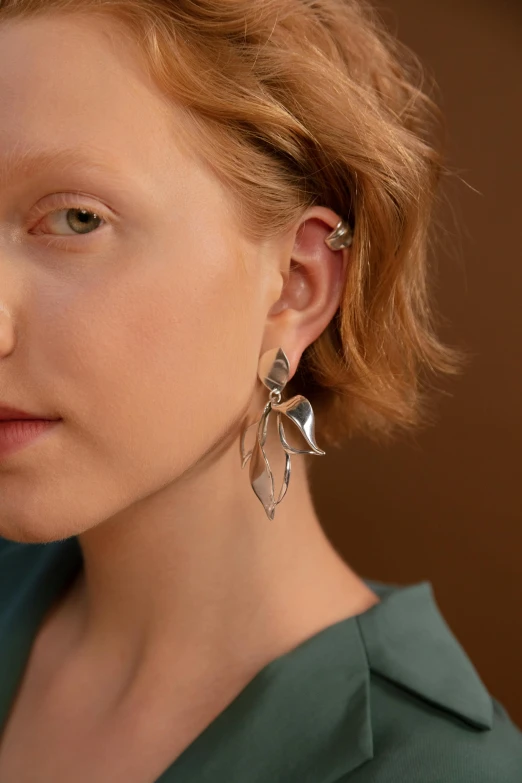 a close up of a person with a cell phone, silver earring, exotic lily ears, met collection, large tall