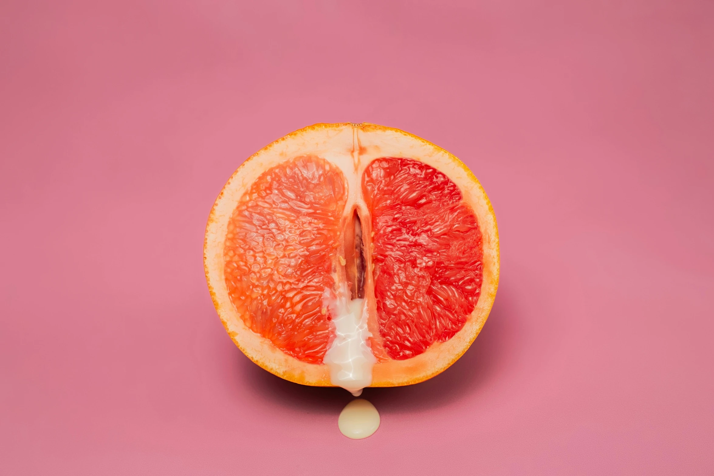 a grapefruit cut in half on a pink background, an album cover, by Elsa Bleda, magic realism, lewd, high resolution print :1 red, alessio albi, uncut