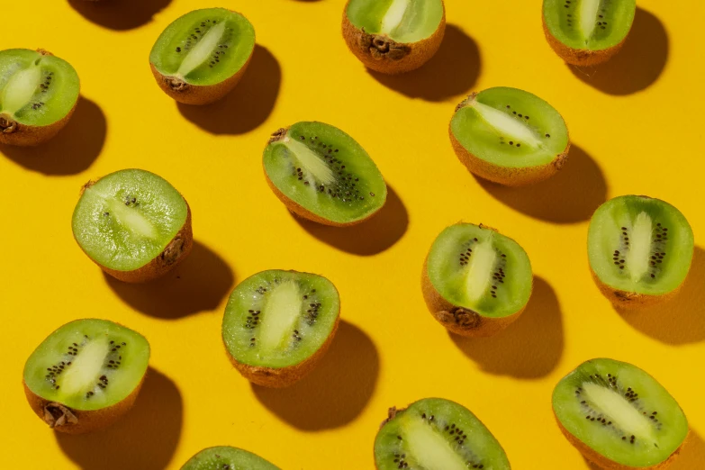 a close up of kiwi slices on a yellow surface, trending on pexels, 🦩🪐🐞👩🏻🦳, “berries, perfectly tileable, with laser-like focus