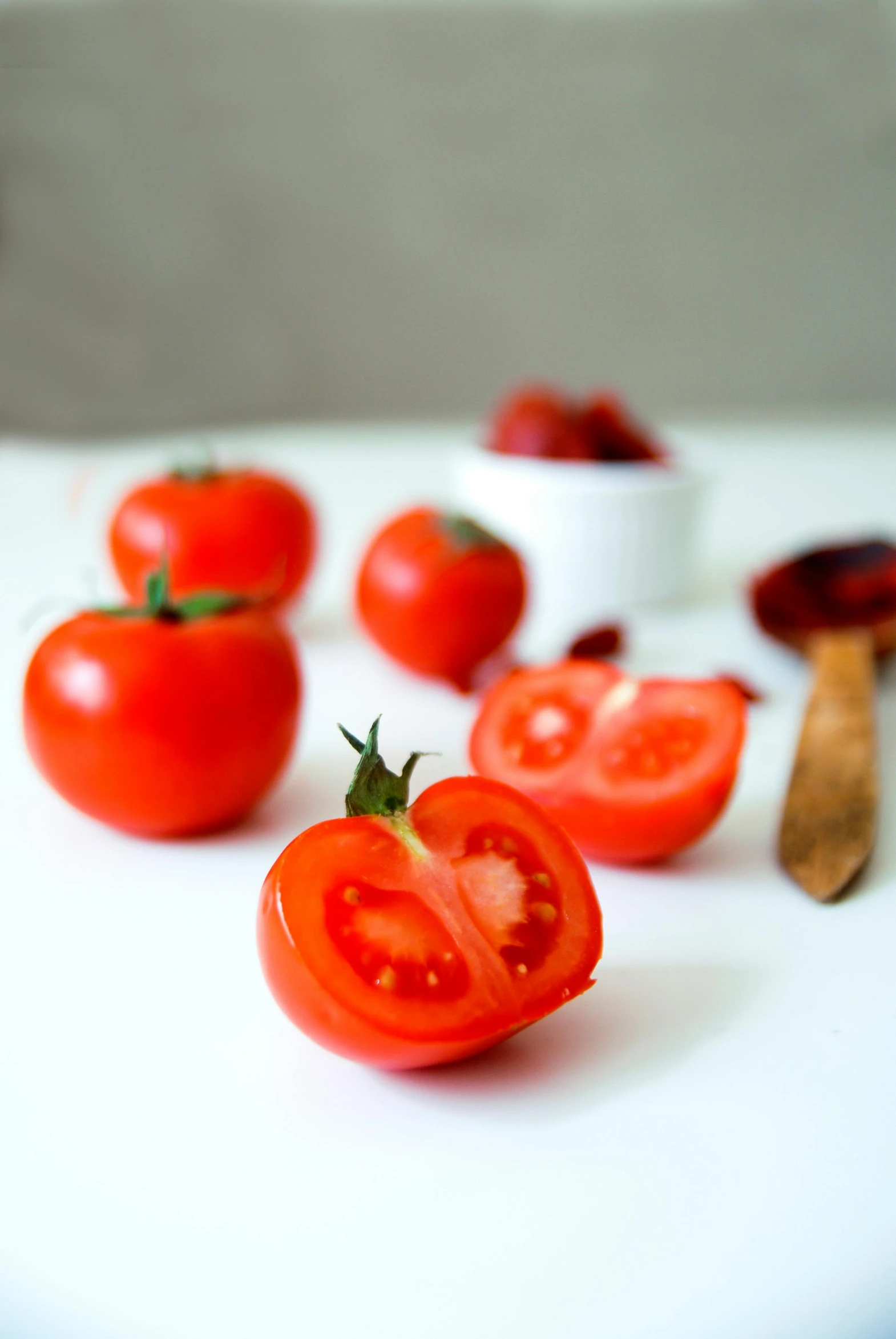 a bunch of tomatoes sitting on top of a cutting board, on a white table, petite, crisp image, fruitcore