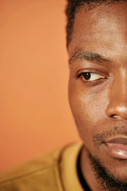 a close up of a person wearing a yellow shirt, an album cover, by Charles Martin, trending on pexels, photorealism, orange pupils, light-brown skin, mkbhd, portrait of young man