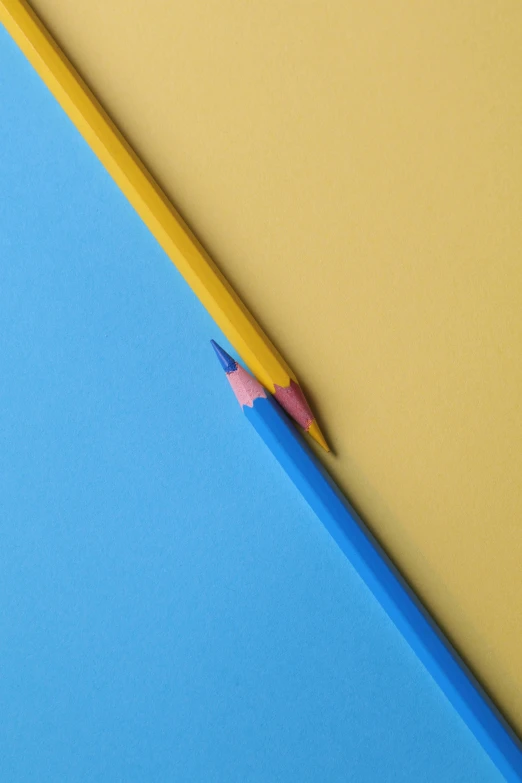 a pencil sitting on top of a blue piece of paper, yellow and blue, colorful aesthetic, promo image, two colors