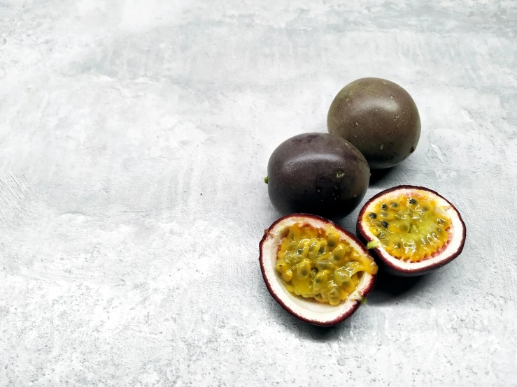 a couple of pieces of fruit sitting on top of a table, trending on pexels, passion fruits, grey, background image, new zealand