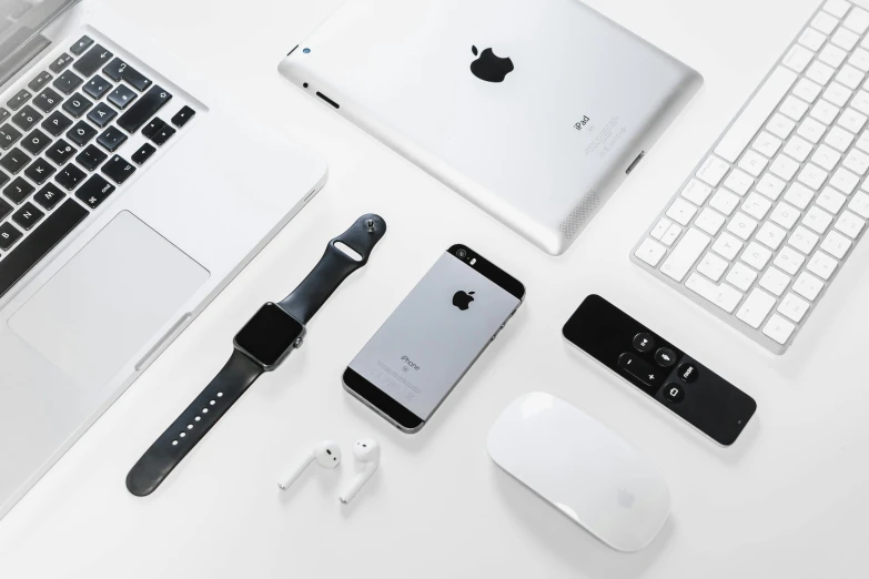a laptop computer sitting on top of a desk next to a keyboard, trending on pexels, minimalism, airpods, silver jewellery, with apple, on grey background