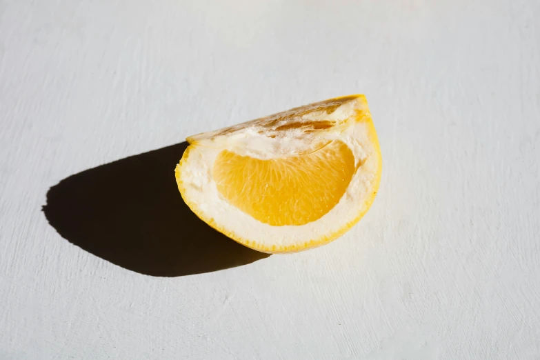 a half of an orange on a white surface, unsplash, with lemon skin texture, natural soft rim light, various posed, made of glazed