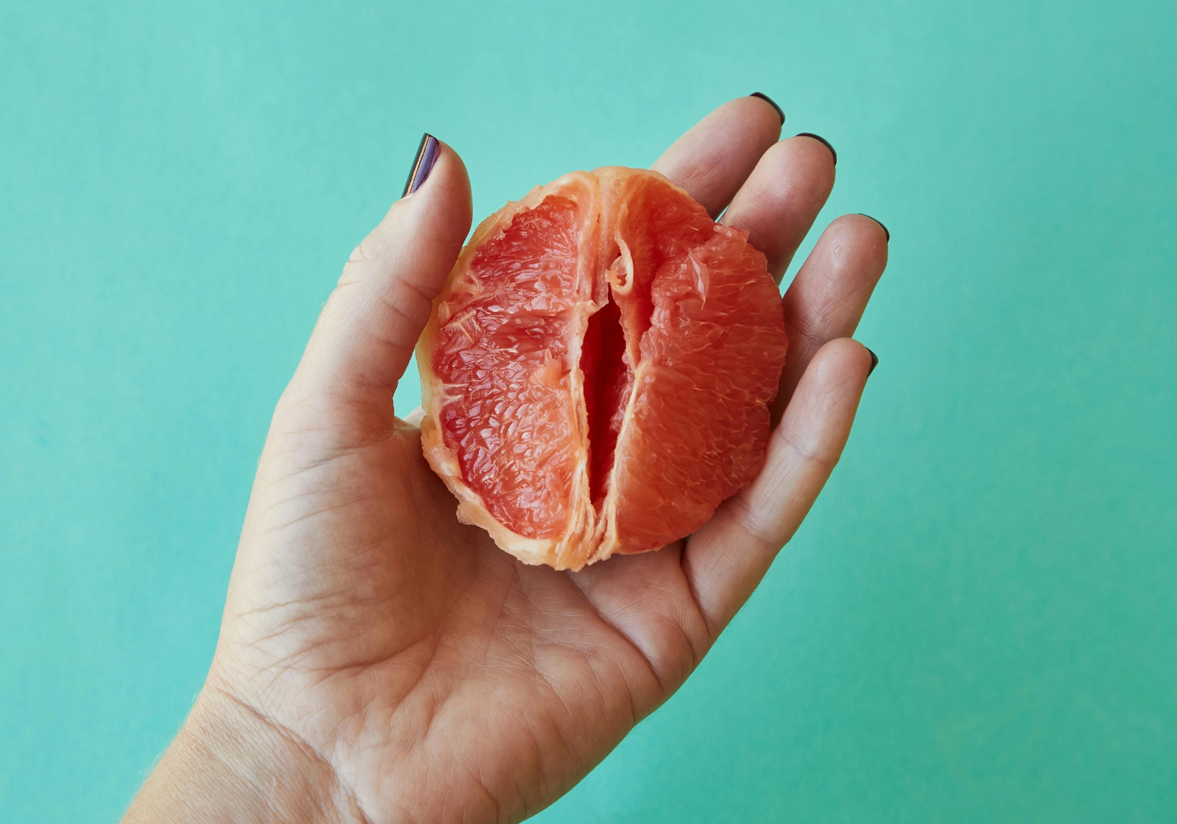 a person holding a grapefruit in their hand, an album cover, by Julia Pishtar, trending on pexels, fleshy musculature, real flesh texture, petite, open palm