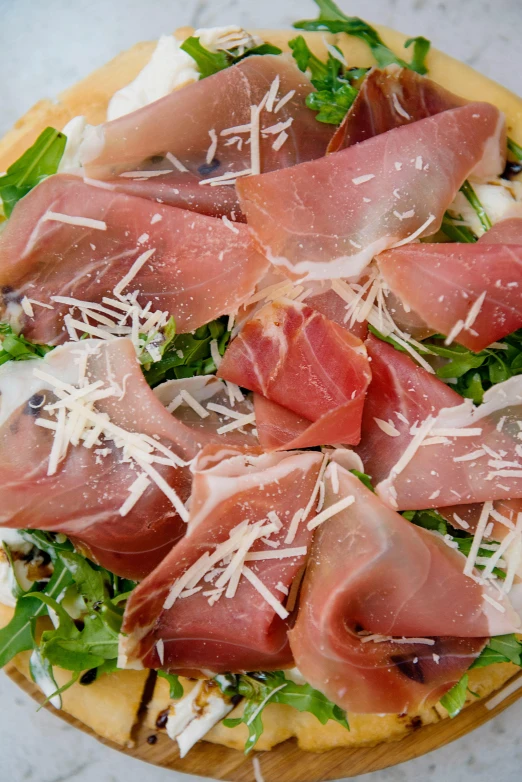 a pizza topped with prosciutto and arugula, zoomed in, daily specials, bells, middle close up