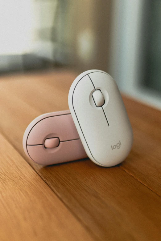 a couple of mouses sitting on top of a wooden table, white and pink, matte finish, on a desk, 360º