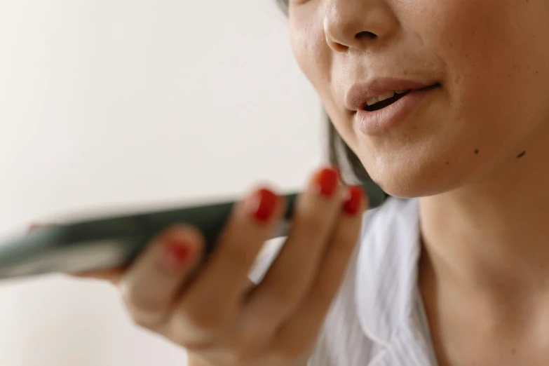 a close up of a person holding a cell phone, by Carey Morris, trending on pexels, hyperrealism, long tongue, asian women, prominent jawline, holding microphone