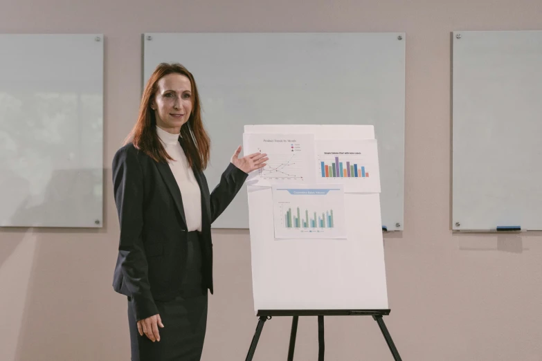 a woman standing in front of a white board, a poster, pexels contest winner, analytical art, ceo, 15081959 21121991 01012000 4k, photo of džesika devic, charts