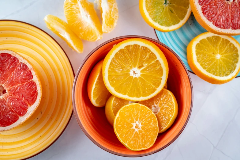 a bowl of oranges sitting on top of a table, by Carey Morris, trending on pexels, cheerful colours, spiraling, 🦩🪐🐞👩🏻🦳, plates of fruit