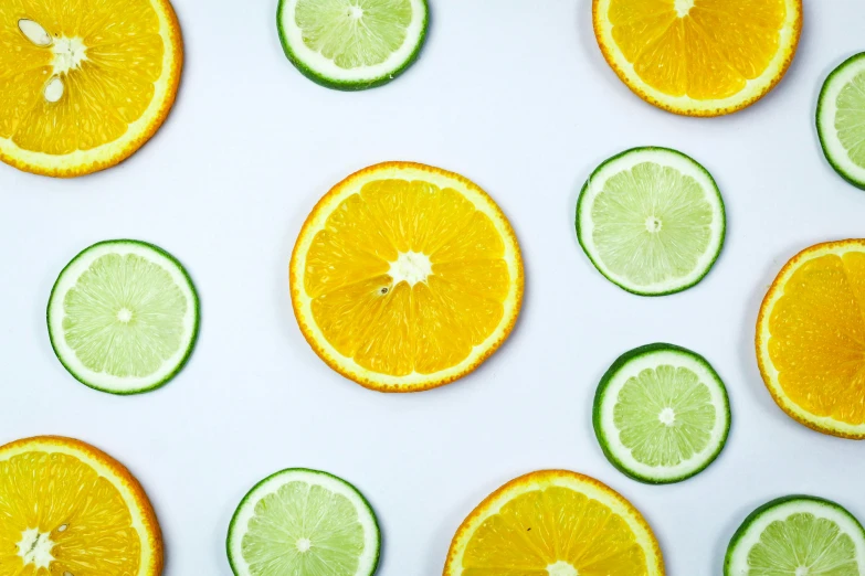 sliced oranges and limes on a white surface, by Carey Morris, trending on pexels, background image, skincare, multicoloured, iconic design