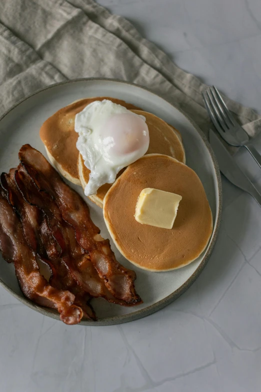 a white plate topped with pancakes and bacon, inspired by Henry Bright, trending on reddit, studio shot, game ready, egg, holiday season