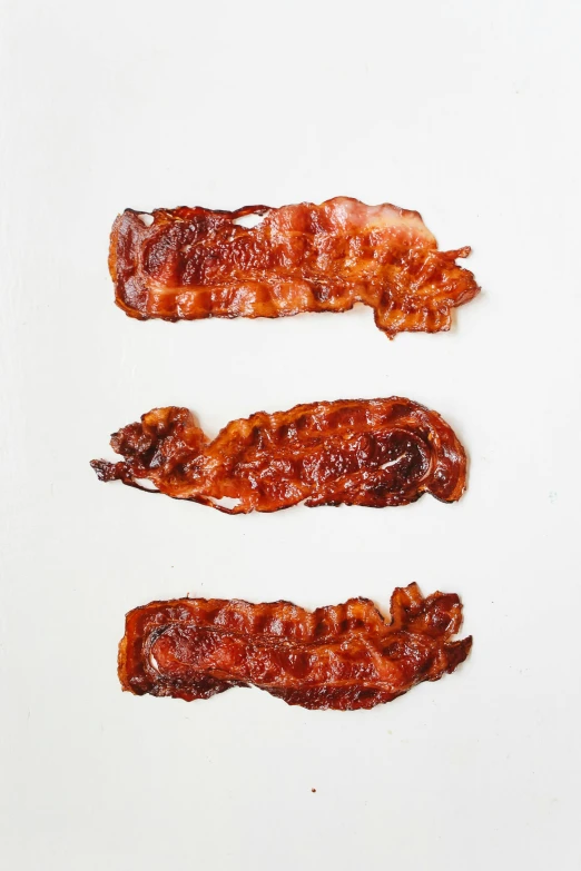 three pieces of bacon on a white surface, unsplash, snapchat photo, epicurious, profile image, made of glazed