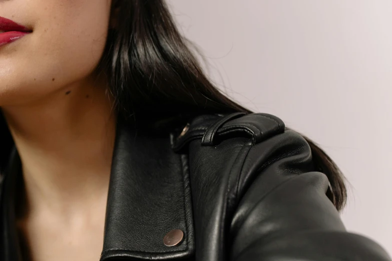 a woman in a leather jacket talking on a cell phone, by Emma Andijewska, trending on pexels, photorealism, skin detail, with straight black hair, bottom body close up, very aesthetic leather jacket