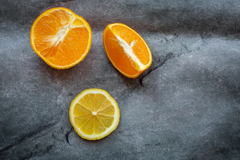 a couple of oranges sitting on top of a table, on a gray background, background image, multiple stories, amanda lilleston