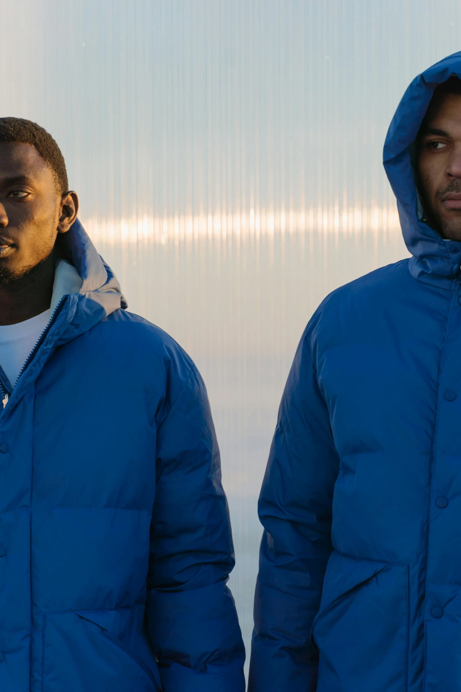 a couple of men standing next to each other, an album cover, inspired by Barthélemy Menn, unsplash, blue parka, puffer jacket, thumbnail, profile pic