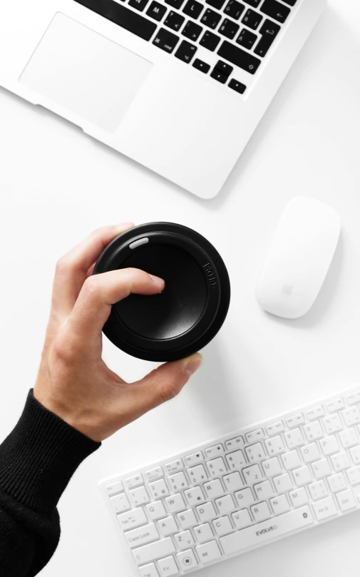 a person holding a camera lens in front of a laptop, by Paul Bird, minimalism, all black matte product, sitting on top of a cryopod, flatlay, klein bottle