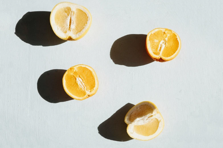 a group of oranges sitting on top of a table, by Simon Marmion, trending on pexels, with lemon skin texture, minimalist composition, back - lit, cut out